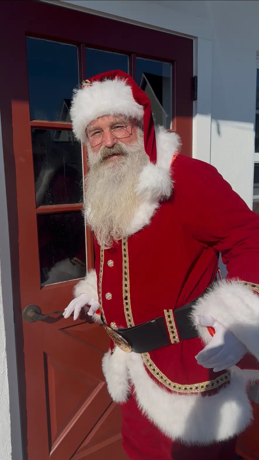 Santa arriving at a red front door for a private home visit